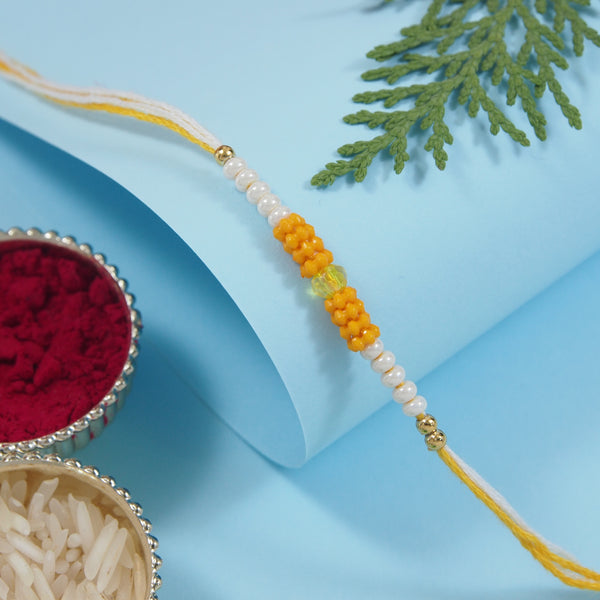 DELICATE PEARL BEADS YELLOW RAKHI WITH ROLI CHAWAL & RAKSHABANDHAN CARD