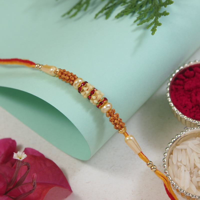 DELICATE PEARL BEADED MAROON RAKHI WITH ROLI CHAWAL & RAKSHABANDHAN CARD